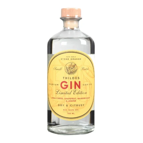 En klar glasflaske med ELG Thildes Gin Limited Edition med træhætte og gul etiket, der beskrives som tør og citrusagtig med smag af grapefrugt, rabarberrod og enebær.